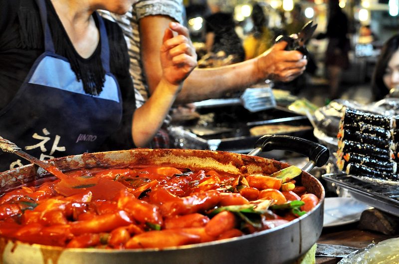 Vendors call to get hungry passerbys to try ddukboki, a dish with spicy rice cakes and fish cakes.